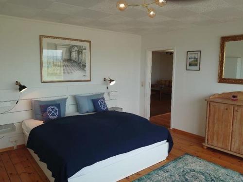 una camera da letto con un letto grande con cuscini blu di Ostsee Huus a Burg auf Fehmarn