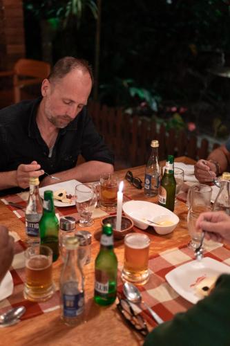 a man sitting at a table with bottles of beer at El Jardin Lodge & Spa in Puerto Misahuallí