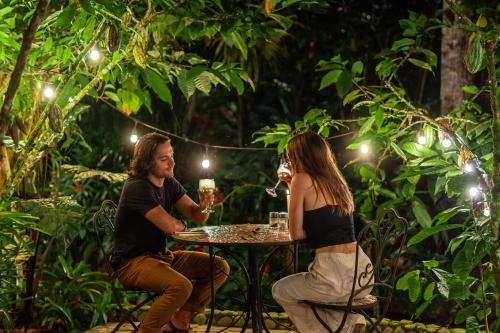 a man and woman sitting at a table with wine glasses at El Jardin Lodge & Spa in Puerto Misahuallí