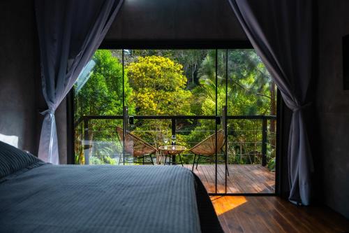 a bedroom with a large window with a view of a deck at Cabana Marabella in Santa Teresa