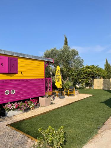 a colorful house in a yard with a lawn at Aigues Marines in Aigues-Mortes