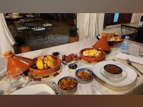 a table with several plates of food on it at Dar S'BAH in Fès