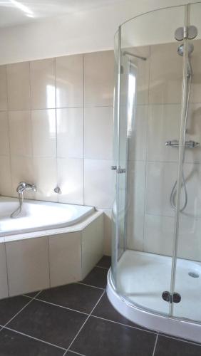 a bathroom with a shower and a tub and a sink at blue lagoon in Fehmarn
