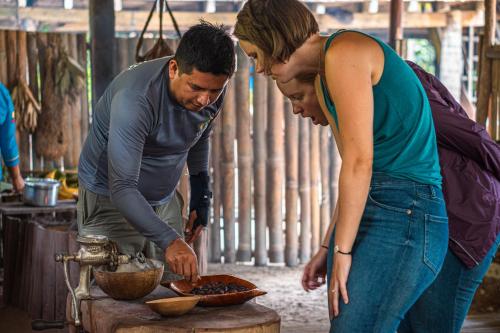 a man and a woman preparing food on a table at El Jardin Lodge & Spa in Puerto Misahuallí