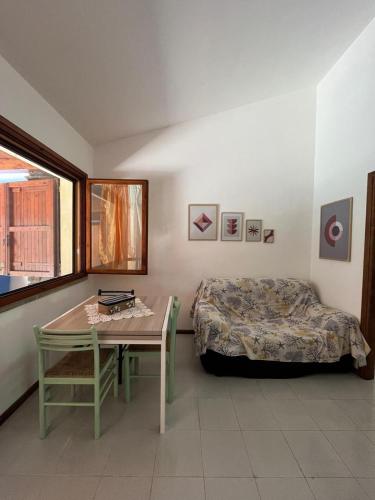 a bedroom with a bed and a table and a table sidx sidx sidx at La Casetta al mare in Stintino