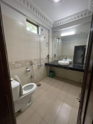 a bathroom with a toilet and a sink at The lodge Guest House in Muzaffarabad