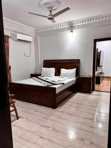a bedroom with a bed and a ceiling fan at The lodge Guest House in Muzaffarabad