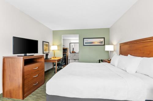 a hotel room with a bed and a flat screen tv at Quality Inn Lexington in Lexington