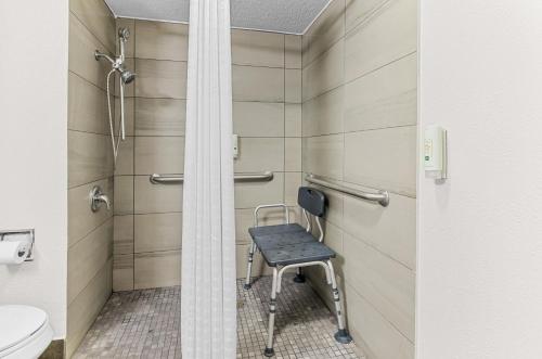 a shower stall with a chair in a bathroom at Quality Inn Lexington in Lexington