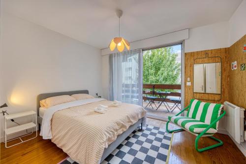 une chambre avec un lit, une chaise et une fenêtre dans l'établissement Alta House - Central Ferney and Family-Friendly, à Ferney-Voltaire