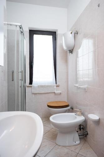 a white bathroom with a toilet and a sink at I Due Olivi - Assisi Living in Castelnuovo