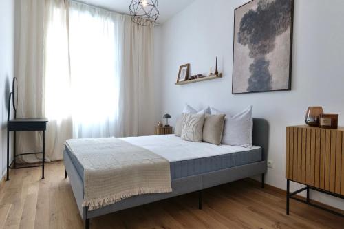 a bedroom with a bed with white walls and a window at Apartment Grace Family in Vienna