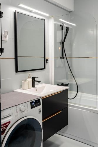 a bathroom with a washing machine and a sink at The Arch apartment in Voluntari