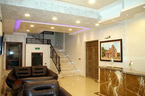 a living room with a couch and a staircase at Hotel Ulpiana, Ethno House in Gracanica