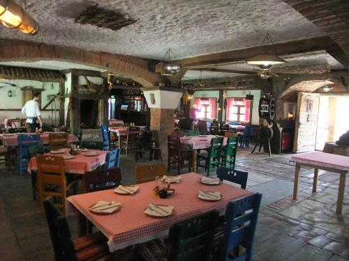 a restaurant with tables and chairs in a room at Hotel Ulpiana, Ethno House in Gracanica