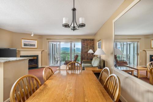 a dining room and living room with a wooden table and chairs at Sunrise Ridge Resort in Pigeon Forge