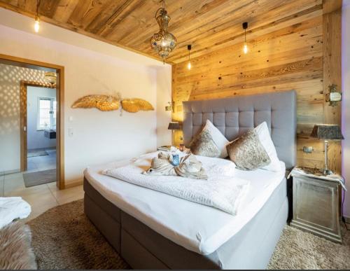 a bedroom with a large white bed with a wooden wall at Relax-Bollendorf in Bollendorf