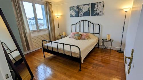 a bedroom with a black bed with pillows on it at Apt 2 pièces, 2 lits, à 15' Paris centre, 30' Disney in Vincennes