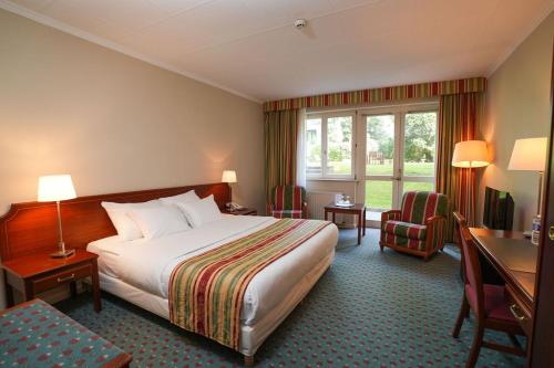 ein Hotelzimmer mit Bett, Schreibtisch und Fenster in der Unterkunft Park Hotel Brussels in Brüssel