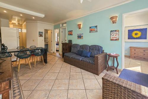 a living room with a couch and a table at 1E - Pe na Areia da Praia do Tombo, 3 Quartos, Ar Cond, 2 WC, 1 vaga e Roupas de Cama in Guarujá