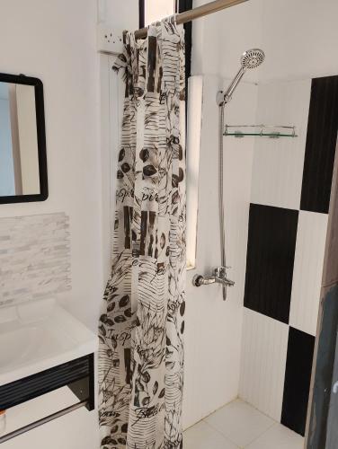 a shower in a bathroom with a shower curtain at Rose villa in Pereybere