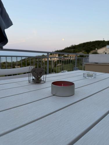 a wooden table with a bowl on top of a deck at House with a terrace overlooking the sea in Marina San Vito