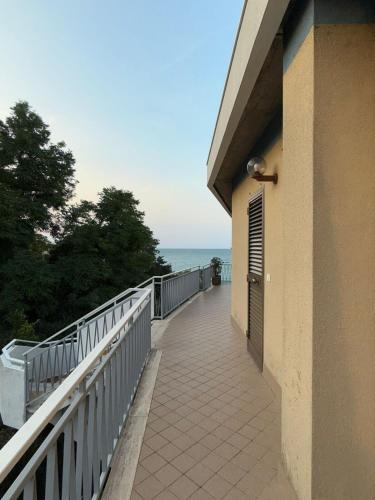 a walkway next to a building with the ocean in the background at House with a terrace overlooking the sea in Marina San Vito