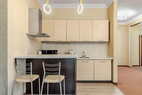 a kitchen with two chairs sitting at a counter at Bukovel Apart in Bukovel