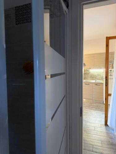 a door leading into a kitchen with a refrigerator at House with a terrace overlooking the sea in Marina San Vito