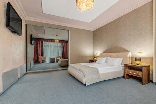 a bedroom with a bed and a large mirror at Bukovel Apart in Bukovel