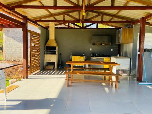 a patio with a wooden table and a kitchen at Chalé do Lago in Sinop