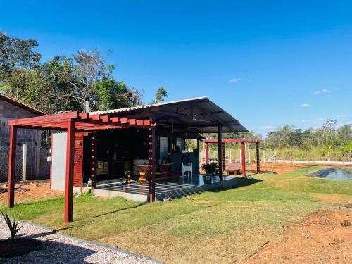 a smallshed with a red roof on the grass at Chalé do Lago in Sinop