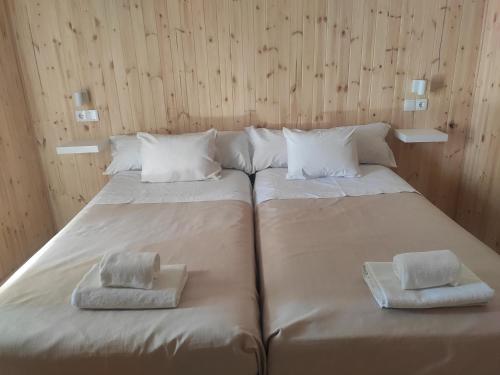 a large bed with two towels on top of it at Cantinho Alentejano in Estremoz