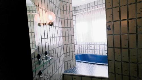 a bathroom with a shower with a blue tub at Ferienwohnung Niesner Mitten in Sterkrade Oberhausen nah am Westfield Centro in Oberhausen