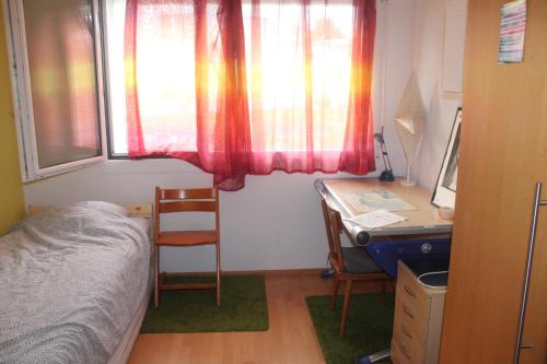 een slaapkamer met een bed, een bureau en een raam bij Liselotte's room 