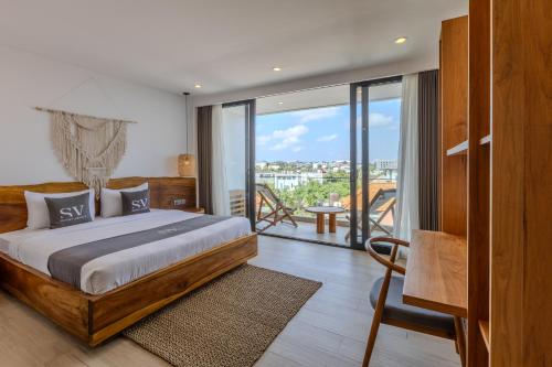 a bedroom with a large bed and a balcony at Sunny Aparts 2 in Canggu