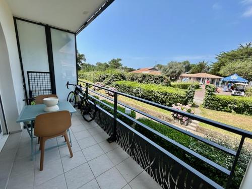 a balcony with a table and a bike on it at Studio Design Chic à Chiberta - plage & green in Anglet