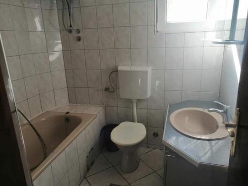 a bathroom with a tub and a toilet and a sink at Vila Bula 1 in Donji Štoj