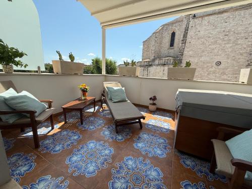 a balcony with chairs and a table and a building at Manna Blue Sky - Exclusive Rooms in Barletta
