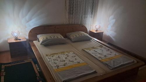 a bed with two pillows and a table with two lamps at Vila Bula 1 in Donji Štoj