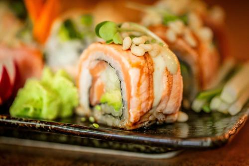 a piece of sushi on a black plate with food at Hotel Medemblik in Medemblik