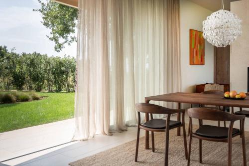 a dining room with a table and chairs and a window at Mondellebotte - Luxus Villa & traumhafter Meerblick in Barat