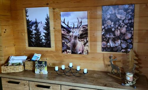 a room with three paintings on a wall with candles at Ferienhaus zum Harzer Hirsch in Seesen