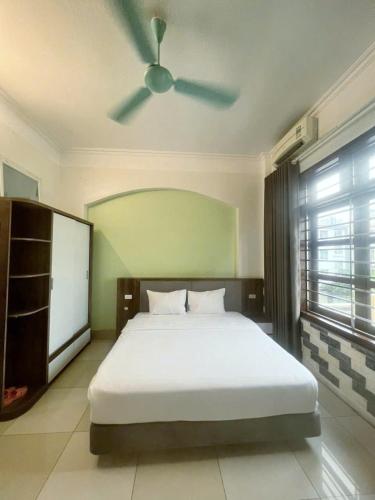 a bedroom with a white bed with a ceiling fan at Diamond Motel in Bắc Giang