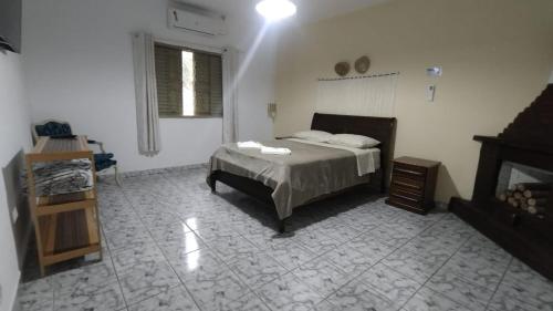 a bedroom with a bed and a fireplace at Pousada Fazenda Vale Verde in Sete Barras
