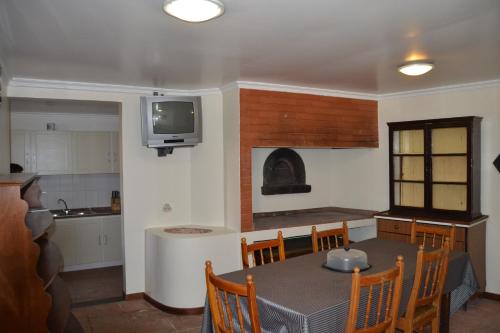 a kitchen and dining room with a table and a tv at Hostel Casal São João in Ribeira Brava