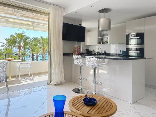une cuisine avec un comptoir et une table avec des chaises dans l'établissement Stylish 1-bedroom apartment with sea view on La Croisette, à Cannes