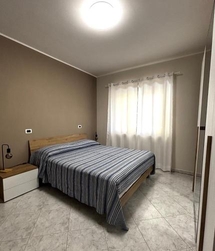 a bedroom with a large bed and a window at Dimora Speranza in San Giovanni Teatino