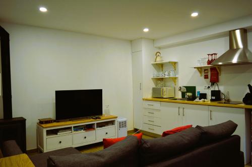 a living room with a couch and a flat screen tv at Moinho do Zorrão in Manteigas
