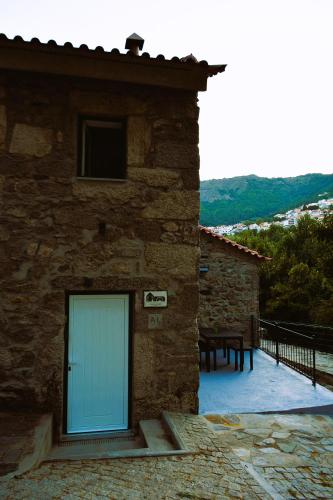 a building with a blue door on the side of it at Moinho do Zorrão in Manteigas